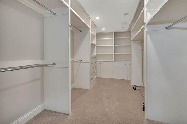 spacious closet featuring light colored carpet