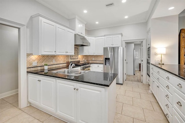 kitchen with dark stone counters, stainless steel appliances, sink, white cabinetry, and light tile patterned flooring