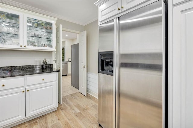 kitchen with built in fridge, white cabinets, and light wood-type flooring