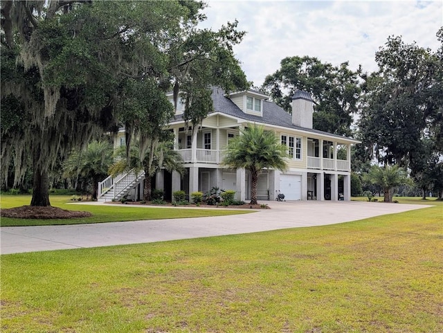2115 Marshview Dr, Shellman Bluff, GA 31331 - raised beach house with stairs, an attached garage, driveway, a front lawn, and a chimney