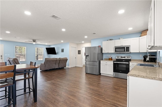 825 Red Hawk Dr, Waynesville, GA 31566 - kitchen featuring stainless steel appliances, open floor plan, dark wood finished floors, white cabinets, and recessed lighting