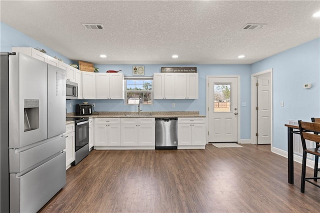825 Red Hawk Dr, Waynesville, GA 31566 - kitchen with stainless steel appliances, dark wood finished floors, a sink, a textured ceiling, and recessed lighting