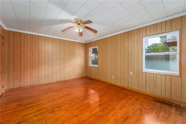 101 Forrest Ave, Waycross, GA 31501 - unfurnished room with plenty of natural light, wood finished floors, a ceiling fan, ornamental molding, and wooden walls
