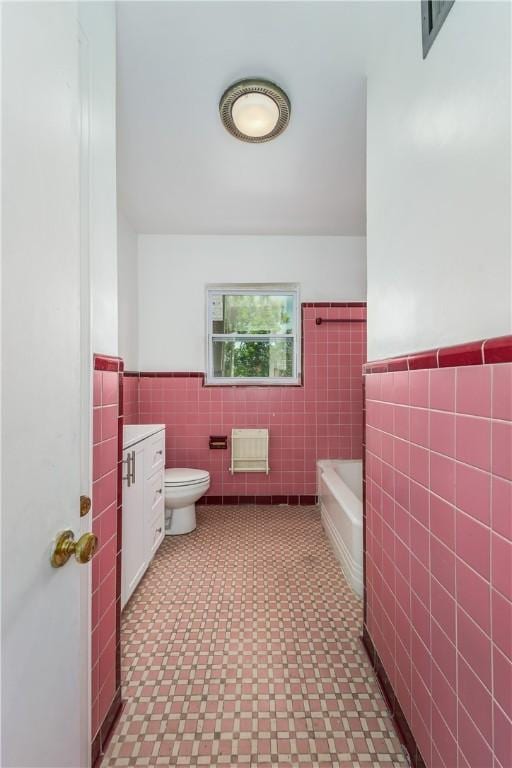 101 Forrest Ave, Waycross, GA 31501 - full bathroom featuring tile walls, tile patterned floors, a wainscoted wall, a bath, and vanity