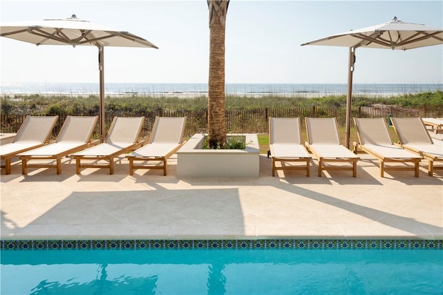 view of pool with a water view and a patio area