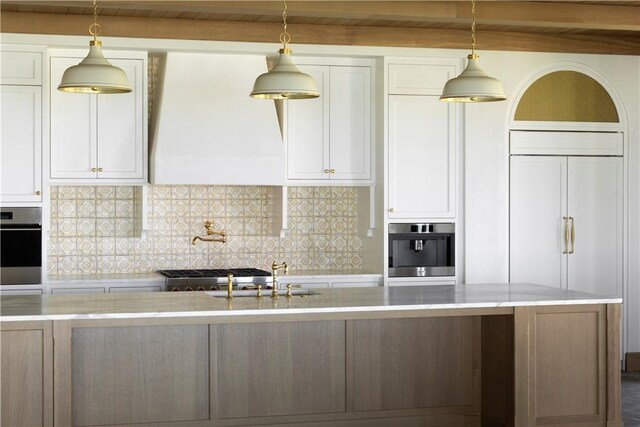 kitchen featuring custom exhaust hood, paneled built in refrigerator, sink, and stainless steel oven