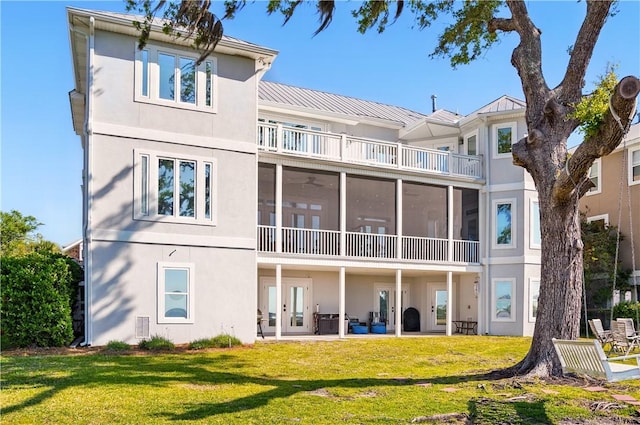 164 Sunrise Dr, Saint Simons Island, GA 31522 - back of house featuring a lawn, a patio, a balcony, and stucco siding