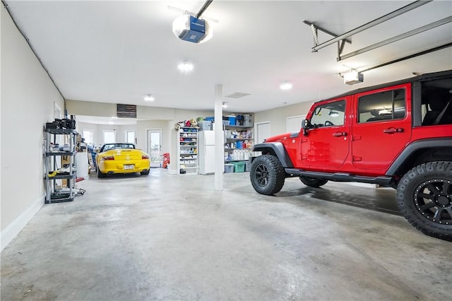 164 Sunrise Dr, Saint Simons Island, GA 31522 - garage with baseboards, freestanding refrigerator, and a garage door opener