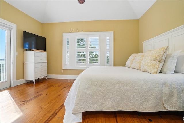164 Sunrise Dr, Saint Simons Island, GA 31522 - bedroom featuring light wood finished floors, vaulted ceiling, and multiple windows