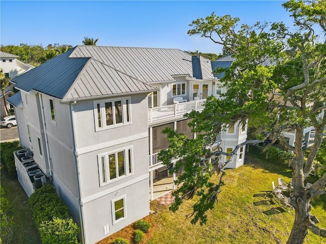 164 Sunrise Dr, Saint Simons Island, GA 31522 - rear view of property featuring stucco siding, a standing seam roof, a balcony, and metal roof