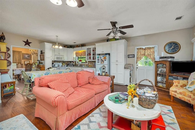 living room with a ceiling fan, dark wood-type flooring, and visible vents