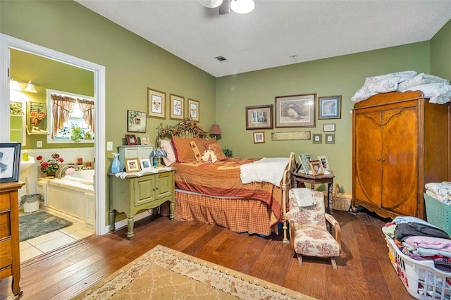 bedroom with wood-type flooring, ensuite bathroom, and visible vents