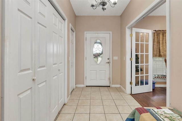 entryway with light tile patterned floors and baseboards