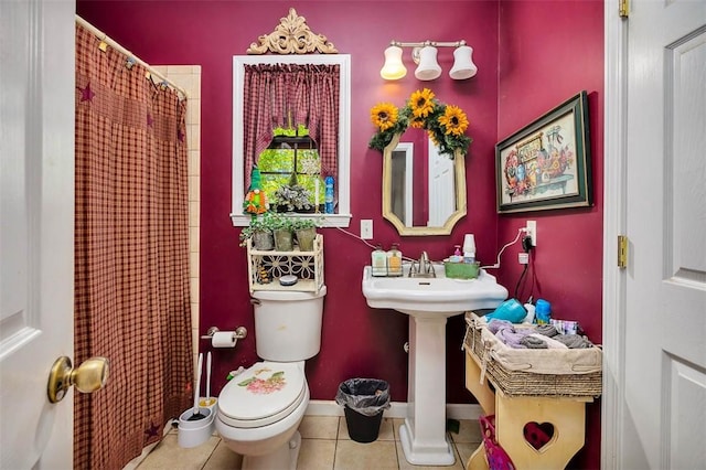 bathroom featuring a sink, tile patterned flooring, toilet, and a shower with curtain
