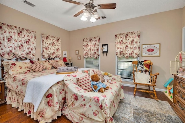 bedroom featuring baseboards, visible vents, and wood finished floors