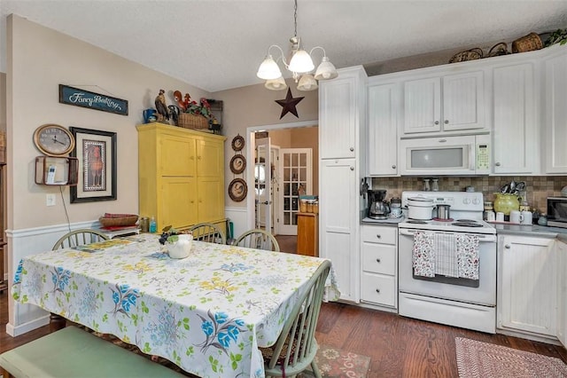 kitchen with a chandelier, white appliances, white cabinets, and dark wood-style flooring