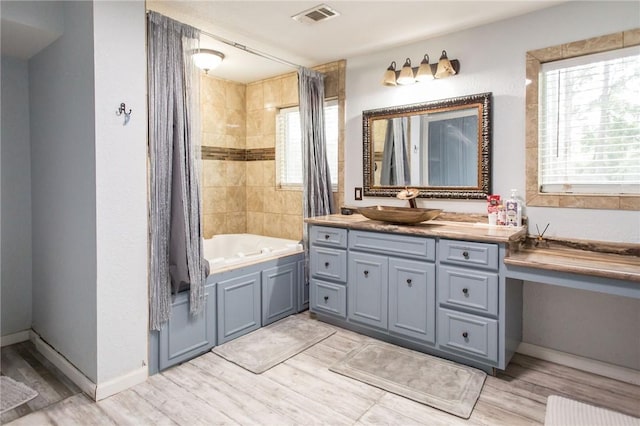 1002 Cherokee Cir, Waycross, GA 31501 - full bathroom with vanity, wood finished floors, shower / bath combo, and baseboards