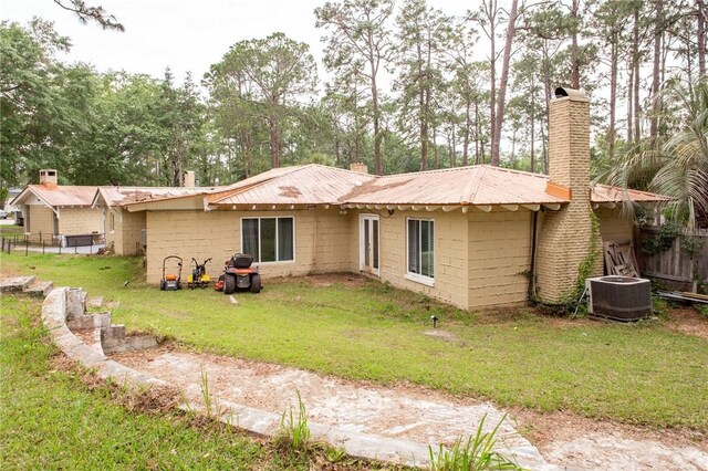 1002 Cherokee Cir, Waycross, GA 31501 - back of property with central AC, a chimney, metal roof, and concrete block siding