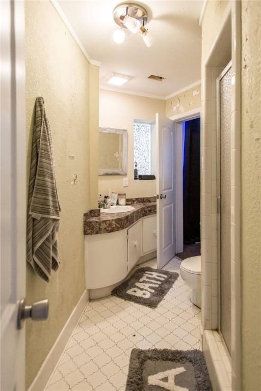 1002 Cherokee Cir, Waycross, GA 31501 - bathroom with crown molding, toilet, vanity, and a stall shower