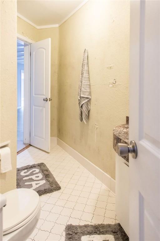 1002 Cherokee Cir, Waycross, GA 31501 - bathroom with crown molding, toilet, and baseboards