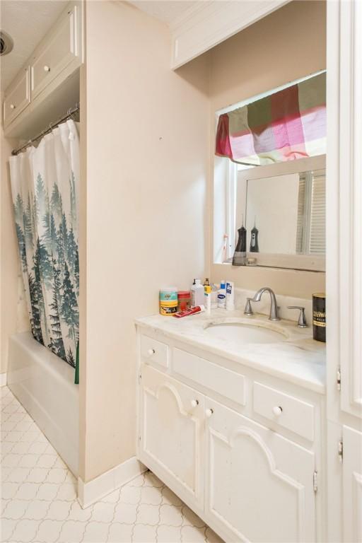 1002 Cherokee Cir, Waycross, GA 31501 - bathroom with vanity, tile patterned floors, shower / bath combo with shower curtain, and baseboards