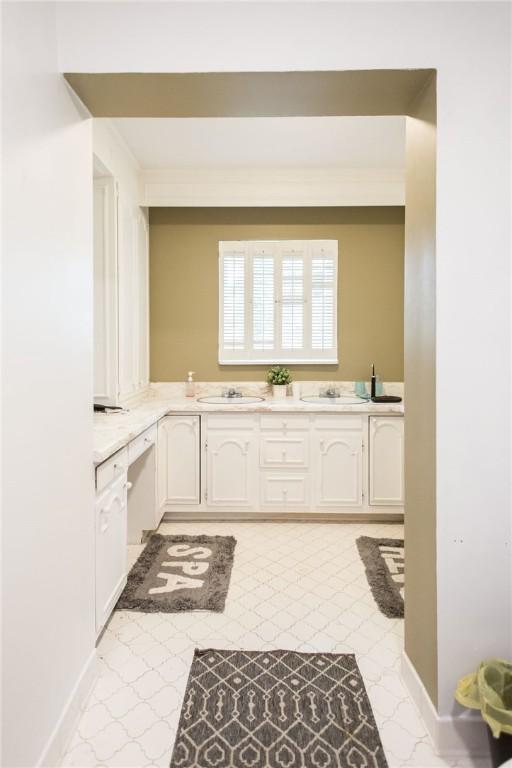 1002 Cherokee Cir, Waycross, GA 31501 - kitchen featuring white cabinets, light countertops, and a sink