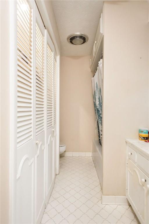 1002 Cherokee Cir, Waycross, GA 31501 - bathroom featuring toilet, tile patterned floors, baseboards, and shower / bath combination with curtain