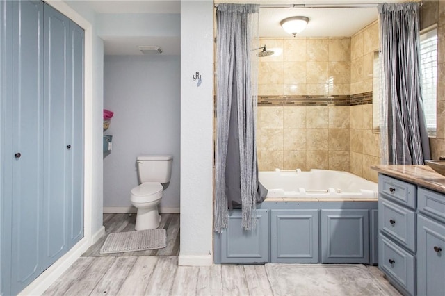 1002 Cherokee Cir, Waycross, GA 31501 - bathroom with toilet, vanity, baseboards, wood finished floors, and shower / bath combination with curtain