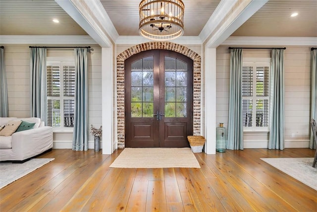 foyer entrance featuring ornamental molding, french doors, hardwood / wood-style flooring, and a healthy amount of sunlight