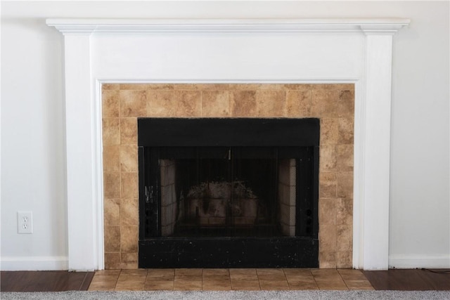 interior details featuring a tiled fireplace