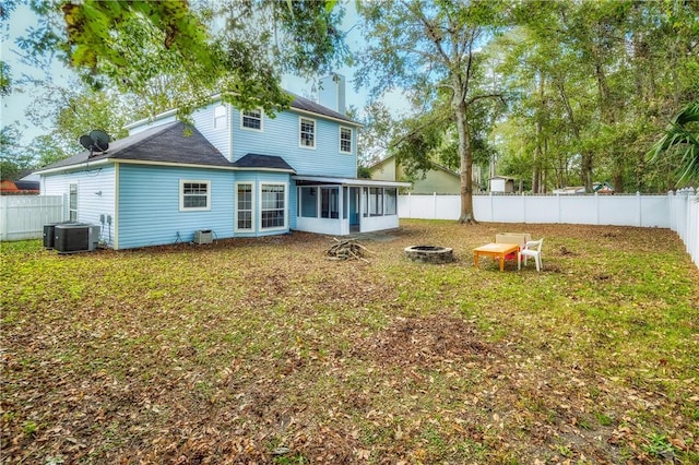 rear view of property with central AC, a fire pit, and a sunroom