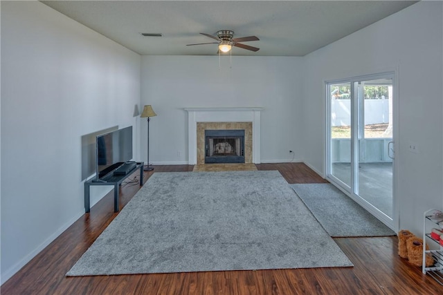 unfurnished living room featuring a fireplace, dark hardwood / wood-style flooring, and ceiling fan