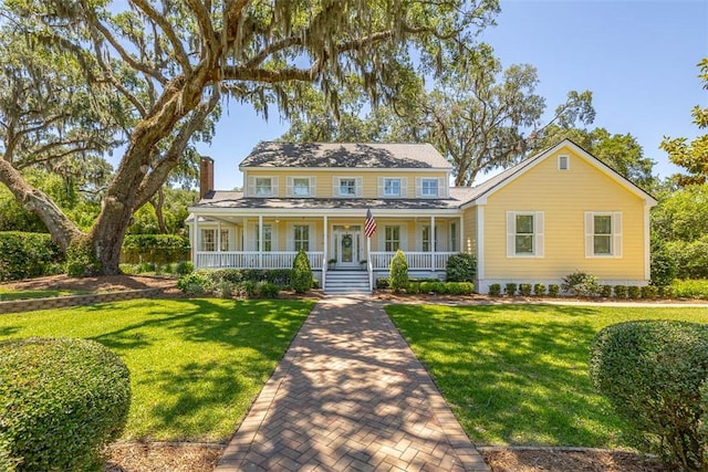 213 Five Pounds Rd, Saint Simons Island, GA 31522 - view of front of house featuring covered porch, a chimney, and a front lawn