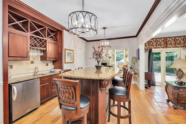 213 Five Pounds Rd, Saint Simons Island, GA 31522 - kitchen with refrigerator, a center island, a chandelier, light stone countertops, and crown molding