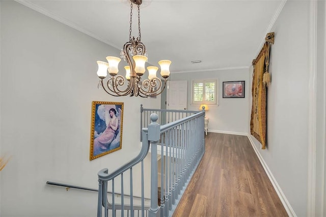 213 Five Pounds Rd, Saint Simons Island, GA 31522 - hallway featuring an upstairs landing, wood finished floors, baseboards, ornamental molding, and a chandelier