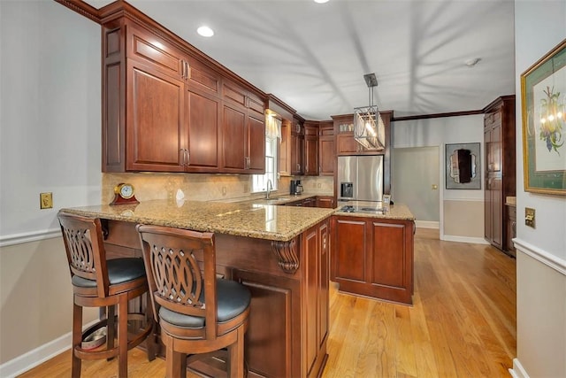 213 Five Pounds Rd, Saint Simons Island, GA 31522 - kitchen featuring stainless steel fridge with ice dispenser, a sink, a peninsula, light wood-type flooring, and recessed lighting