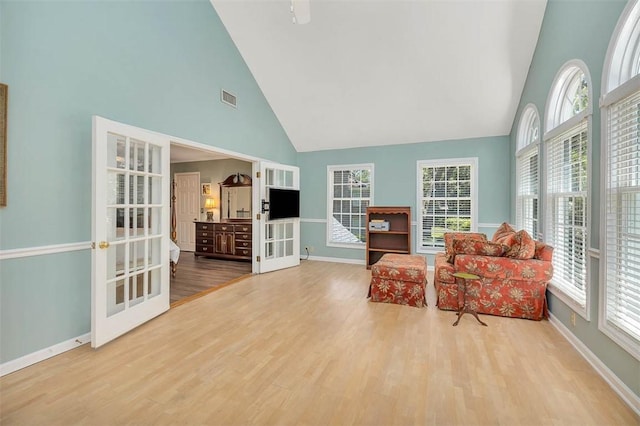 213 Five Pounds Rd, Saint Simons Island, GA 31522 - sitting room featuring high vaulted ceiling, french doors, plenty of natural light, and baseboards