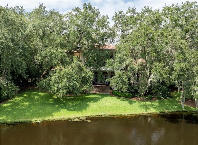 back of property featuring a water view and a yard