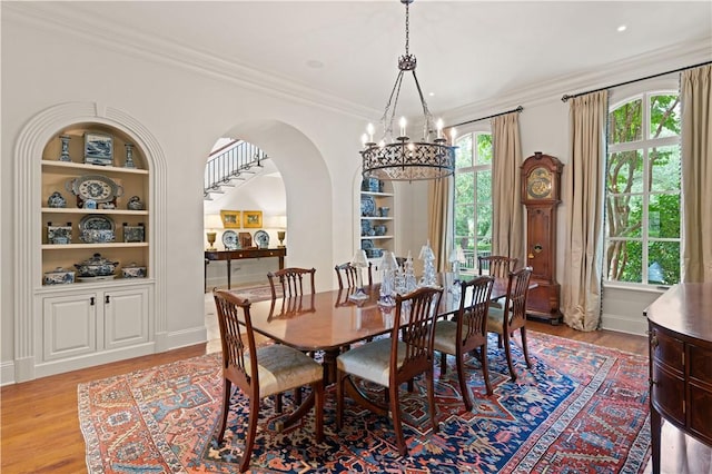 dining space featuring light wood-type flooring, built in shelves, and a wealth of natural light