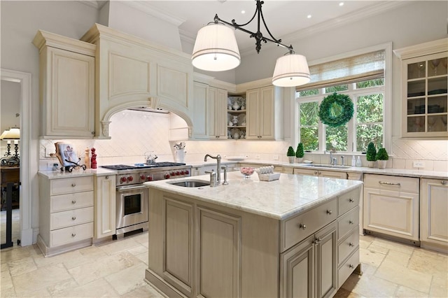 kitchen featuring range with two ovens, stone tile flooring, cream cabinetry, and a sink