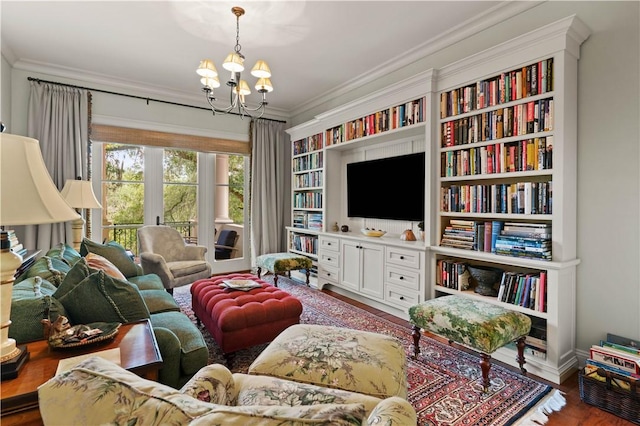 living room with a notable chandelier, wood finished floors, and crown molding