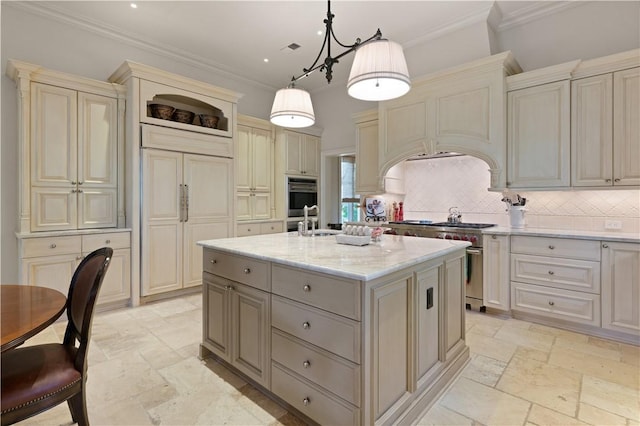 kitchen with cream cabinetry, a center island with sink, stone tile floors, decorative backsplash, and high quality appliances