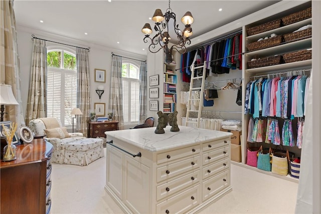 spacious closet with a chandelier and carpet flooring