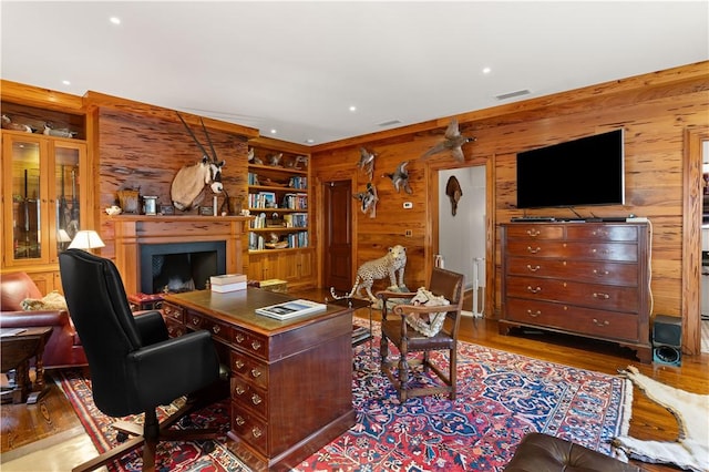 office area featuring recessed lighting, wooden walls, a fireplace, wood finished floors, and visible vents