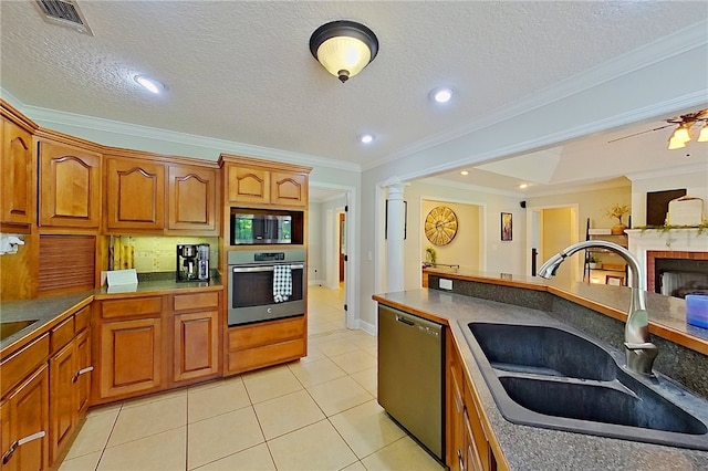 kitchen featuring crown molding, a sink, brown cabinetry, stainless steel appliances, and visible vents