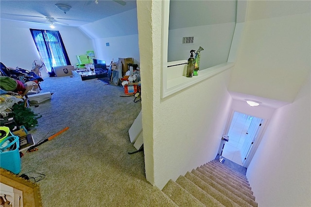 interior space featuring visible vents, a ceiling fan, carpet, and vaulted ceiling