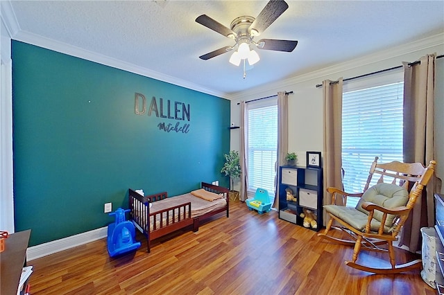 bedroom with baseboards, ornamental molding, a ceiling fan, and wood finished floors