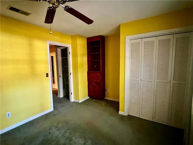 unfurnished bedroom with ceiling fan, a closet, and dark carpet