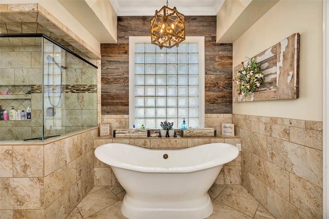 bathroom featuring independent shower and bath, an inviting chandelier, tile walls, and ornamental molding