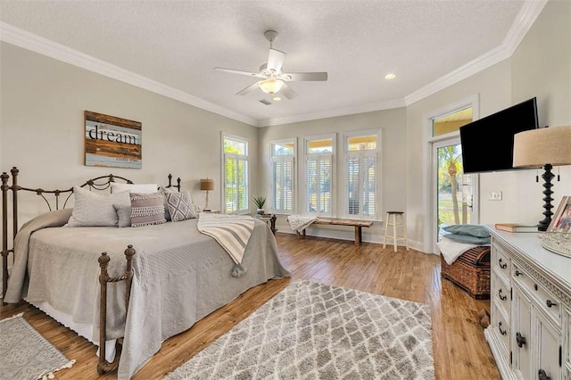 bedroom with ceiling fan, crown molding, light hardwood / wood-style floors, and a textured ceiling